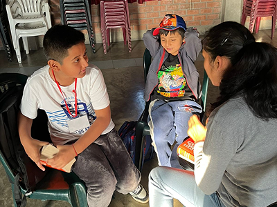 Catequista de Infancia Misionera conversando con dos niños